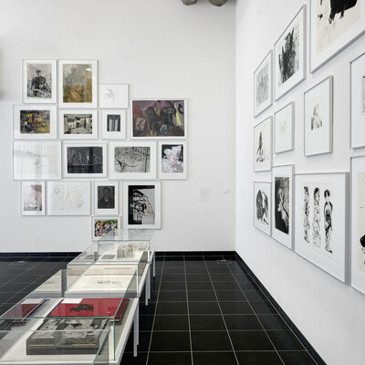 Blick in Raum VI mit zwei Blockhängungen und Tischvitrinen mit Künstlerbüchern